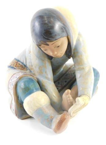 A Lladro porcelain figure of a seated girl, with mottle glazes, 17cm high.