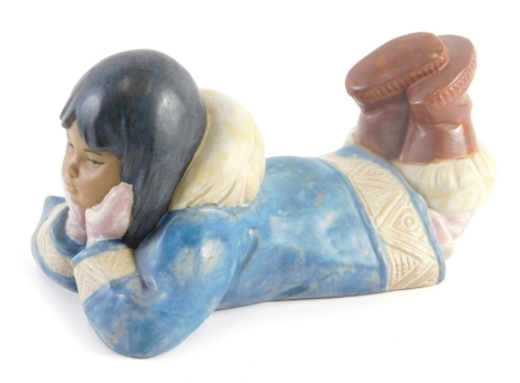 A Nao porcelain figure, of a young Eskimo girl laying on her front, mottled glaze.