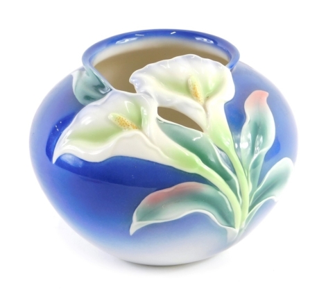 A Franz porcelain vase, decorated with lilies on a blue ground, 14cm high.