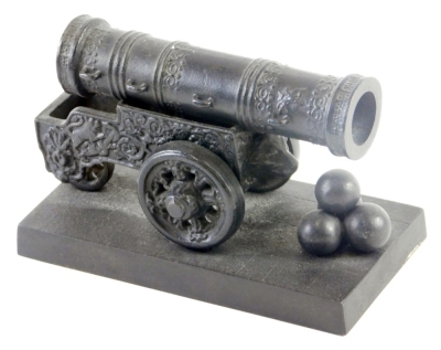 A miniature Russian cast iron model of a 16thC Tsar cannon, the cannon profusely decorated with four cannon balls, on a square base, 12cm long.