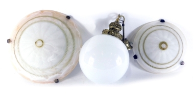 A pair of frosted glass ceiling shades, of compressed dome form, with textured centres, 42cm diameter, and a wall hanging with milk glass orb shade and brass fixture, in a wicker basket. (4)