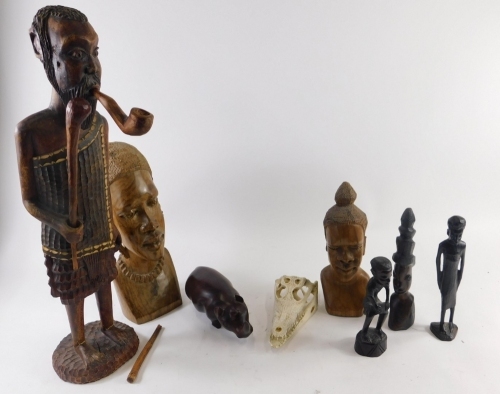 A collection of carved African hardwood figures, to include a tall figure with staff, rhino, etc.