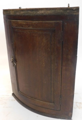 A George II oak bow front hanging corner cupboard, with fielded panel door, moulded cornice, 92cm high.