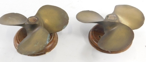 A pair of brass boat propellers, on wooden mounts, 20cm long.