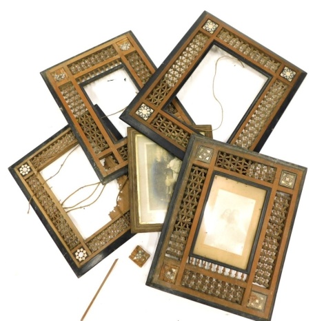 A set of four of heavily carved Eastern mother of pearl part ebonised frames, with a pierced baluster style panelling, 50cm x 39cm, a black white photograph of a child. (5, AF)