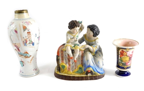 A continental bisque glazed figure group of a girl and child, each in flowing robes, the child sat on table on gilt lined base, 22cm high, a 19thC Coalport style vase and further famille rose Chinese style vase. (3,AF)