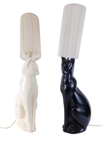 A pair of black and white cat lamps, each in standing poses with modern electrical features, and shades, 59cm high, 90cm high all in. (2)  WARNING! This lot contains untested or unsafe electrical items.  It is supplied for scrap or re-conditioning only. 