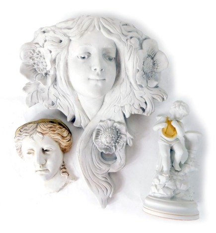 An Art Nouveau style wall hanging of a lady, 39cm high, similar decorated cherub ornaments and further wall mask. (3)