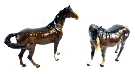 A Beswick pottery horse, in brown and white colour way, head lowered, 19cm high, and another printed marks beneath. (2)