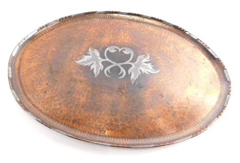 A Paul Gilling copper and pewter tray, in the Arts and Crafts style after Hugh Wallis, centred with heart and leaves, partially hammered, initialled, 38cm wide.