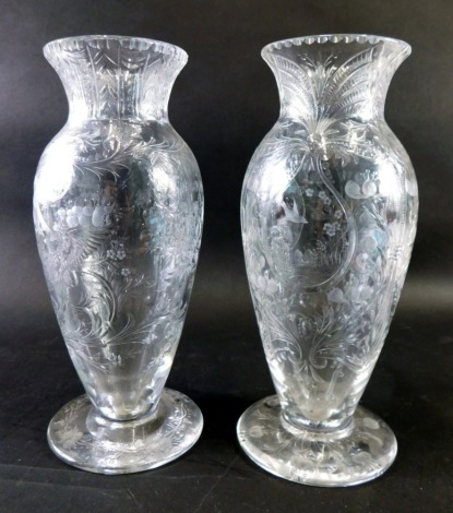 A pair of 'Rock Crystal' etched and clear lead crystal vases, each delicately decorated with panels of birds, trees and mountains, surrounded by further scrolls and flowers, on circular feet, set with further etched entwined flowers, unmarked, possibly 19