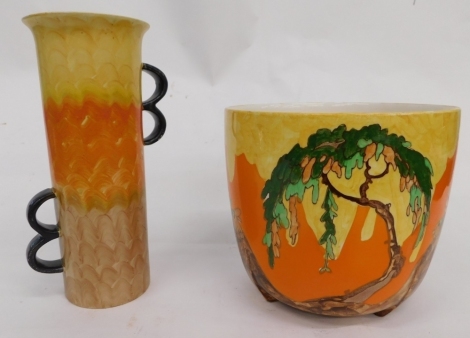 A 20thC Empire ware pottery vase, decorated in yellow, orange and brown stripes, with four black glazed handles, marked beneath, 29cm high, and a similarly decorated jardiniere marked Memory Lane, hand painted with flowers, printed marks beneath. (2)