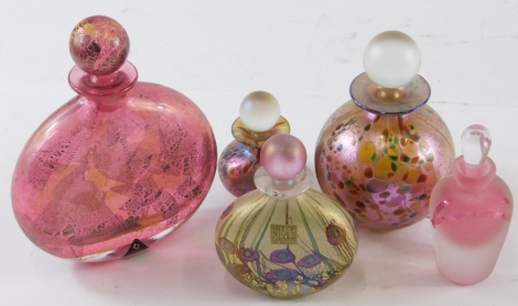 Various 20thC opalescent glass perfume bottles, to include Isle of Wight glass, profusely decorated with flowers, on a gilt coloured and green ground, with pink orb stopper, labelled, 12cm high, another Isle of Wight glass perfume bottle Ditchfield style,