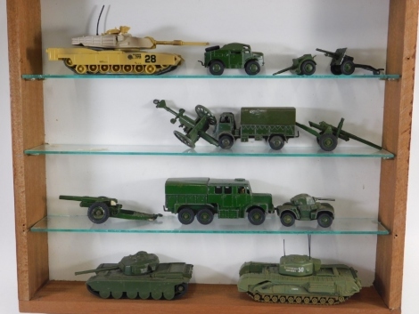 A glazed display cabinet, containing various Dinky and other diecast army trucks, etc., the cabinet 47cm wide.