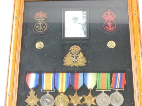 A World War I and World War II medal group, comprising 1914-15 Star, Campaign and Victory medals for World War I, and World War II Atlantic, and 1939-45 Stars, Campaign and Victory medals, with other iron on material badges and photograph, in case, the re