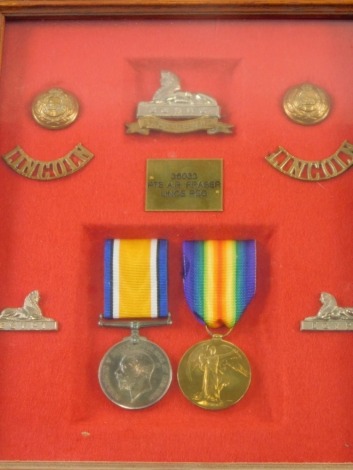 A WWI medal group, comprising Campaign and Victory medals, buttons, shoulder badges, Sphinx badges, etc., in case marked 36033 PTE AR FRASER LINCS REG, the case 31cm x 25cm.