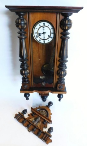 A late 19th/early 20thC Vienna wall clock, in a walnut and ebonised case, the enamel dial with Roman numerals, 121cm high overall.