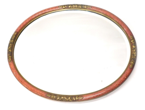 A 1920s oval wall mirror, with bevel plate and pink and gilt embossed and painted frame, 53cm high, 44cm wide.