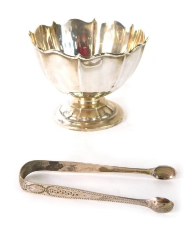 A George V silver sugar bowl, of floral form on a domed foot and a pair of sugar tongs with bright cut decoration, Birmingham 1919, 12.5cm diameter, 5.01oz overall.