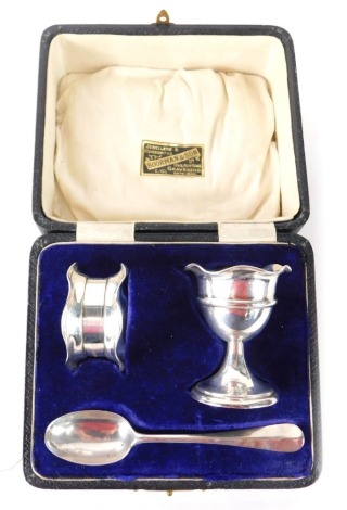 A George V silver christening set, comprising egg cup (loaded) napkin ring and spoon with rat tail, the egg cup Birmingham 1918, 2.24oz all in, in a fitted case.