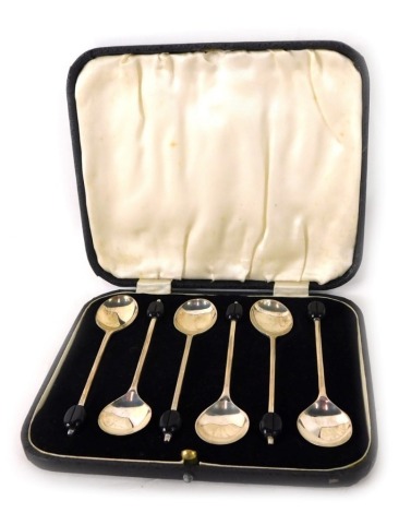 A set of six George V silver coffee spoons, each with a stylised Bakelite bean to the handle, Sheffield 1933, in a fitted case.