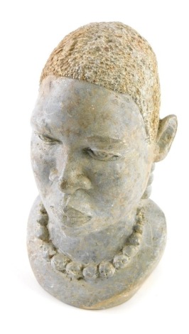 A carved stone African tribal head, quarter profile, gentleman wearing bead necklace, 27cm high.