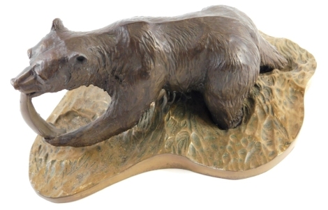 A 20thC bronzed figure of a bear, eating fish on brass naturalistic base, unsigned, 13cm high.