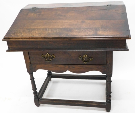 A 19thC oak tabletop clerk's desk, with plain fall and vacant interior, on an associated oak stand, with frieze drawer, on turned legs joined by block stretchers, the top 38cm high, 93cm wide, 67cm deep.