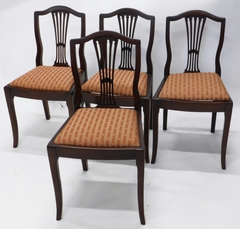 A set of four mahogany dining chairs, each with inverted pierced splats, drop in seats, in later mitre striped material, on sabre front legs, 88cm high. (4)