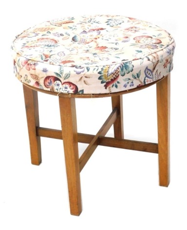 A 20thC stool, with overstuffed seat, on square legs joined by an X stretcher, 47cm high, 48cm diameter.