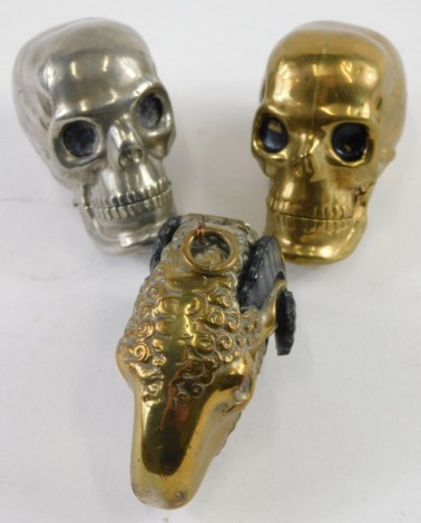 Three novelty plated Vesta cases, comprising two skulls and a ram's head, with match strike base, 4cm high. (3)