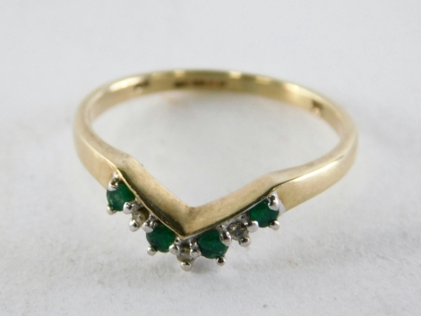 A 9ct gold wish bone ring, set with four emeralds and three tiny diamonds, ring size O, 1.9g all in.