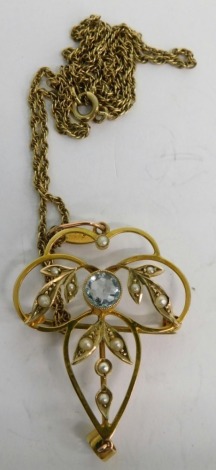 An early 20thC Art Nouveau seed pearl pendant, centred with blue stone with entwined setting, 5cm high, attached to a slender link necklace, unmarked.