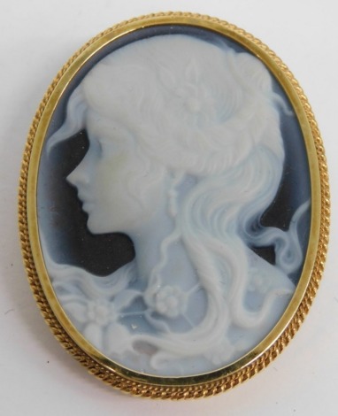 A blue agate cameo, side quarter profile, in a 9ct gold mount with rope twist surround and plain pin back, 4cm high, in associated Vinten case.