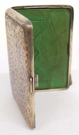 An Edward VII silver pocket card case, with green leather fitted interior for stamps and calling cards, vacant cartouche, chased scroll decoration, thumb mould handles and a vacant cartouche, Birmingham 1907, 9cm long, 2oz all in.