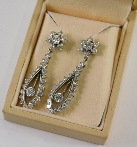 A pair of diamond drop earrings, each set with round brilliant cut stones, in claw setting, the two largest central stones approx 0.15ct, surrounded by stones graduated in size approx 0.08ct to 0.02ct overall, in a white gold setting, unmarked, 6g all in,