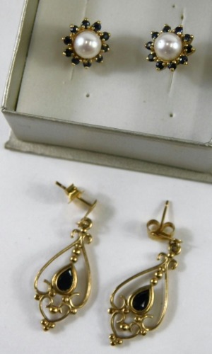 Two pairs of 9ct gold earrings, comprising a cultured pearl and sapphire stud, and a pair of garnet set scroll drop earrings, 4.4g all in. (2 pairs)