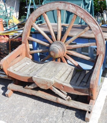 An unusual garden seat, with water wheel back, serpentine seat, and X shaped ends, 120cm wide.