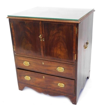 A George III mahogany commode, with cross banded top above double cupboards and two drawers on splayed feet with brass side carrying handles and later glass top, 76cm high, 66cm wide, 54cm deep.