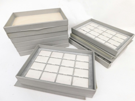 A group of grey finish jewellery display trays, each with stacking lid, cushioned interior, some with inserts. (a quantity)