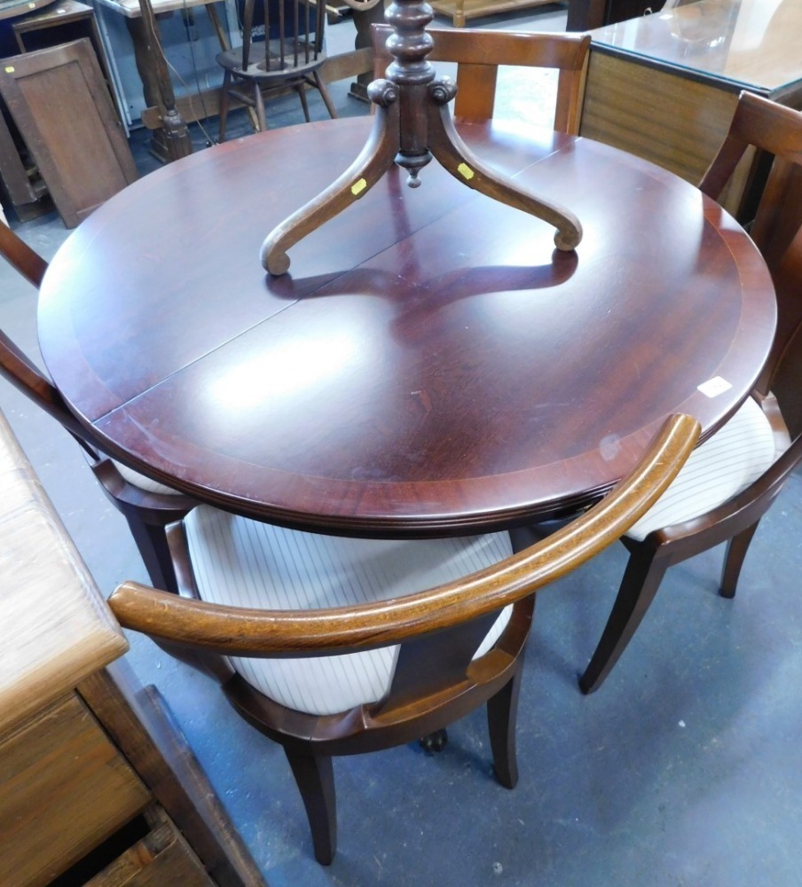 A circular extending dining table, and four chairs.