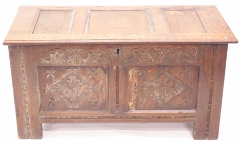 A 17thC oak coffer, with three panelled top, demi lune carved frieze, two lozenge carved panels and channelled stiles, 50cm high, 97cm wide, 47cm deep.