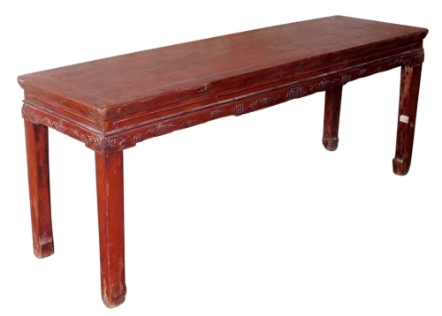 A Chinese red stained table, 56cm high, 140cm wide, 42cm deep.