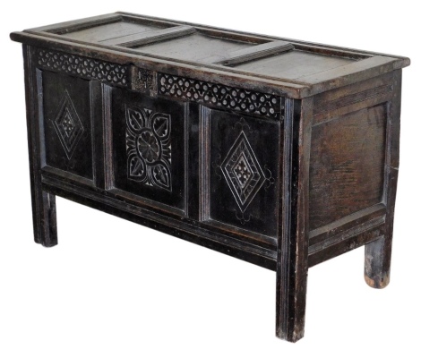 A 17thC oak coffer, with panelled top, arabesque carved lozenge and floret three panelled front, raised on stiles, 72cm high, 120cm wide, 49cm deep.