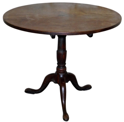 A George III mahogany supper table, with circular tilt tip, baluster turned pillar, and three out swept legs, 90cm diameter.