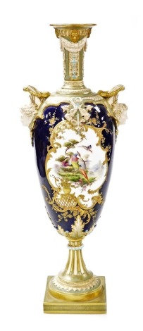 A Royal Worcester porcelain twin handled vase, circa 1897, of baluster form, decorated centrally with a reserve depicting exotic birds in landscape, against a cobalt blue ground with gilt highlights, with two male mask head handles, on a square turquoise 