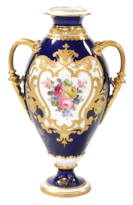 A Royal Crown Derby porcelain twin handled vase, circa 1907, decorated centrally with a floral reserve within a gilt shield shaped floral embellished border, against a cobalt blue ground, with gilt handles and gilt banding, stamped to underside and number