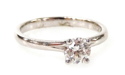 A platinum and diamond solitaire ring, with round brilliant cut diamond in four claw setting, 0.60ct, in a raised basket on a plain band stamped PT950, ring size N, 3.6g all in.