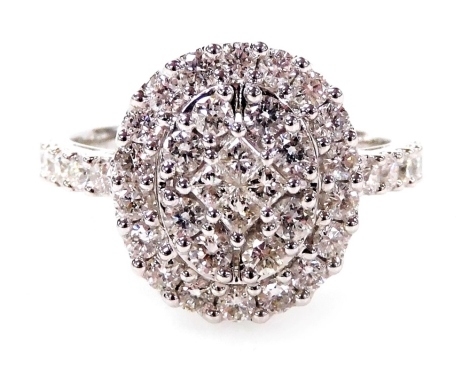 A 18ct white gold diamond cluster ring, set with an arrangement of round brilliant and square cut diamonds with two layer ring head and five round brilliant cut diamond shoulders, each in claw setting totalling approximately 1.16ct, ring size M, 4.3g all 