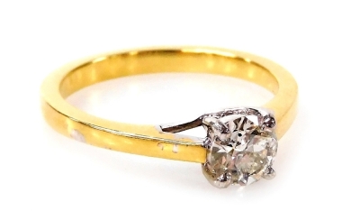 An 18ct gold and diamond solitaire ring, with round brilliant cut diamond totalling 0.53ct, in a four claw white basket setting on a plain yellow metal band, ring size M, 3.2g all in.